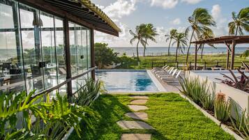 Una piscina al aire libre, sillones reclinables de piscina