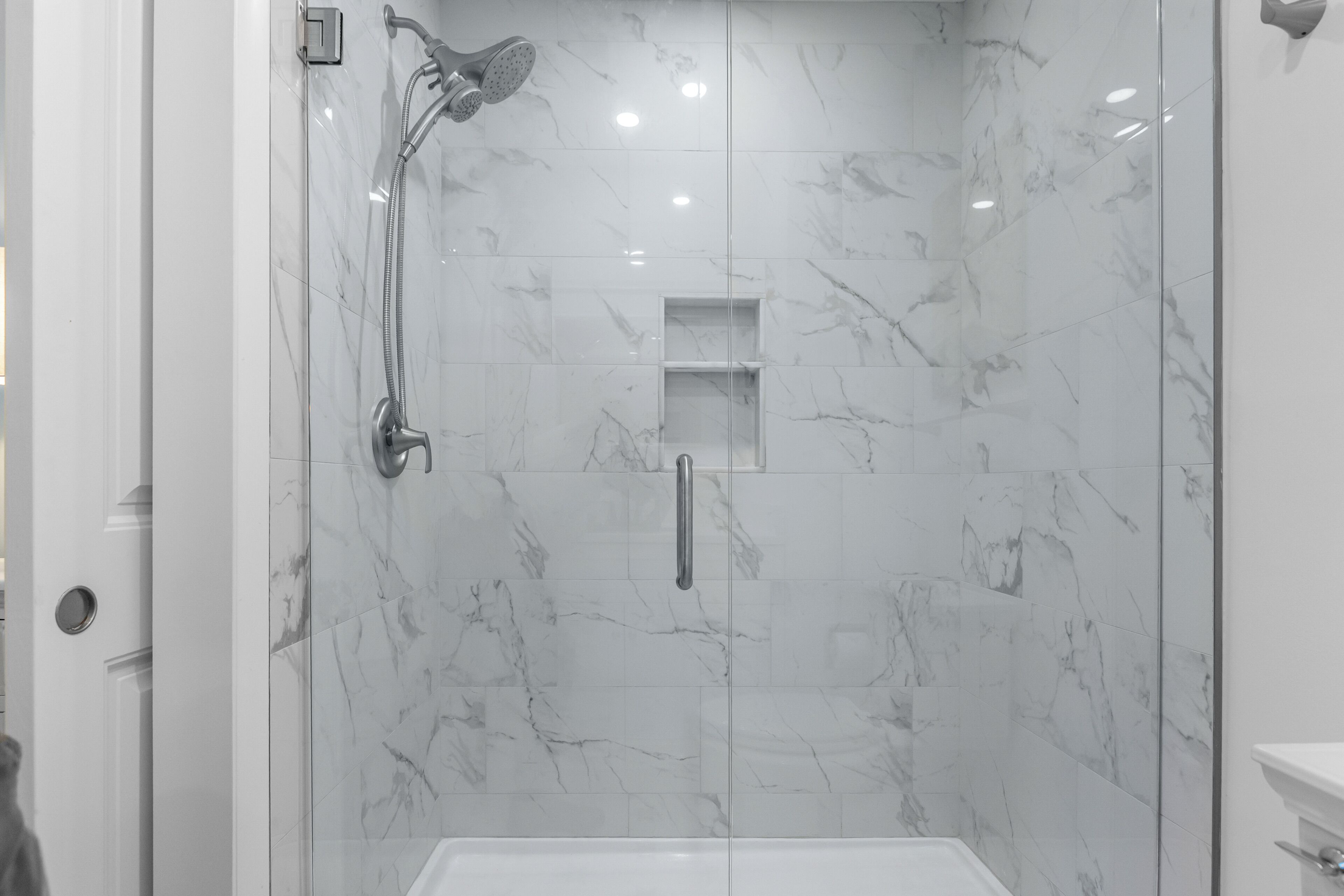 A bathroom with a shower, a toilet, and a sink.