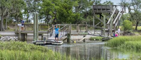 A wooden bridge over a calm river with people walking.