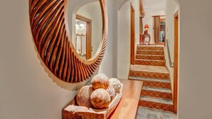 A hallway with a wooden mirror, a wooden bench with decorative spheres, and a staircase with patterned tiles. - The Crescent Ridge, 2BR Ski Condo, Walk to Lifts! (Park City)