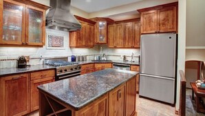 A kitchen with wooden cabinets, a stainless steel range, and a granite countertop. - The Crescent Ridge, 2BR Ski Condo, Walk to Lifts! (Park City)