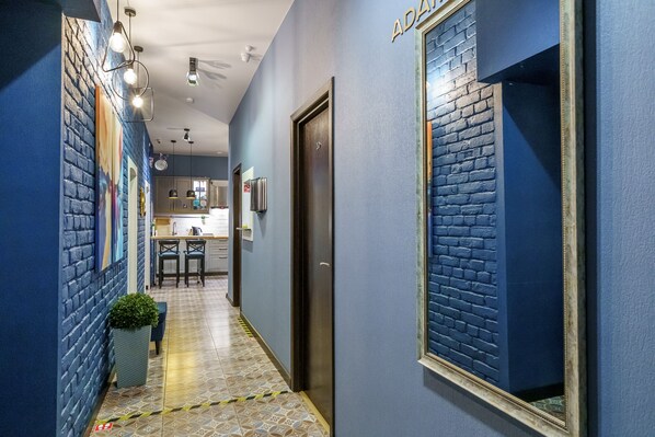 Stunning hallway with a blue brick accent wall, mirrored wall, and patterned tile floor.