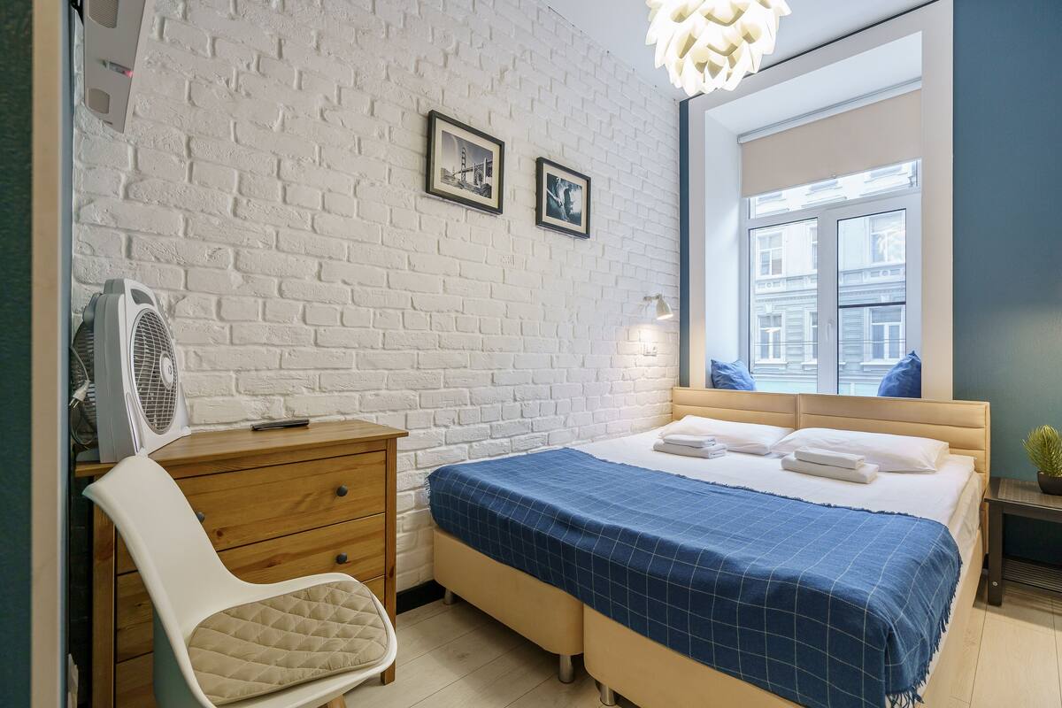 Relax in a stylish room with a comfortable bed, framed artwork, and a city view.