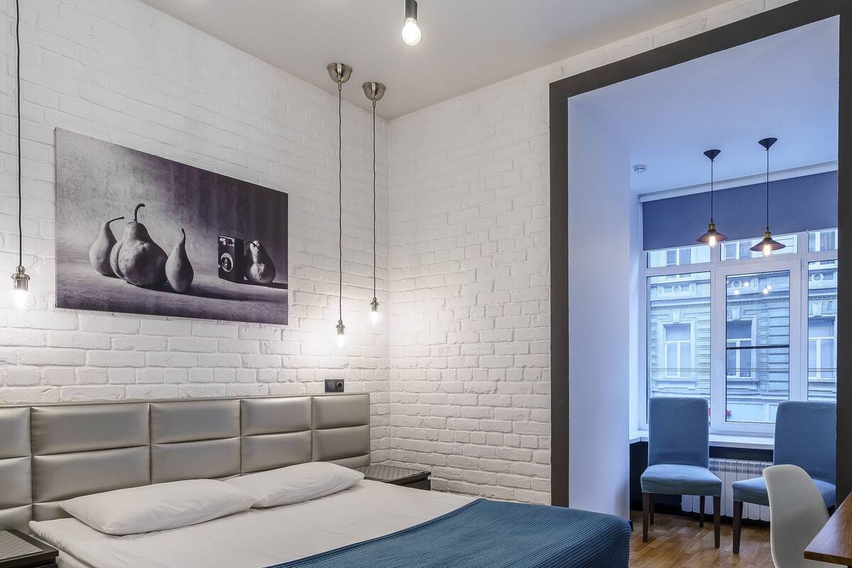 Relax in a serene space with a large bed, white linens, and a cozy seating area.