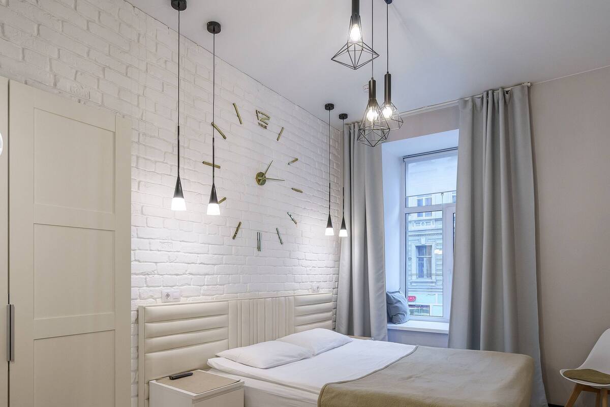 Relax in a stylish room with a made bed, bedside table, and city view.
