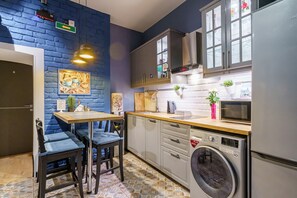 Enjoy cooking in this kitchen with a brick accent wall, stainless steel appliances, and a dining table.