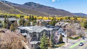 A residential area with houses, a road, and a mountain in the background. - The Moose Lodge - New 2BR, Walk to PCMR / Main St! (Park City)