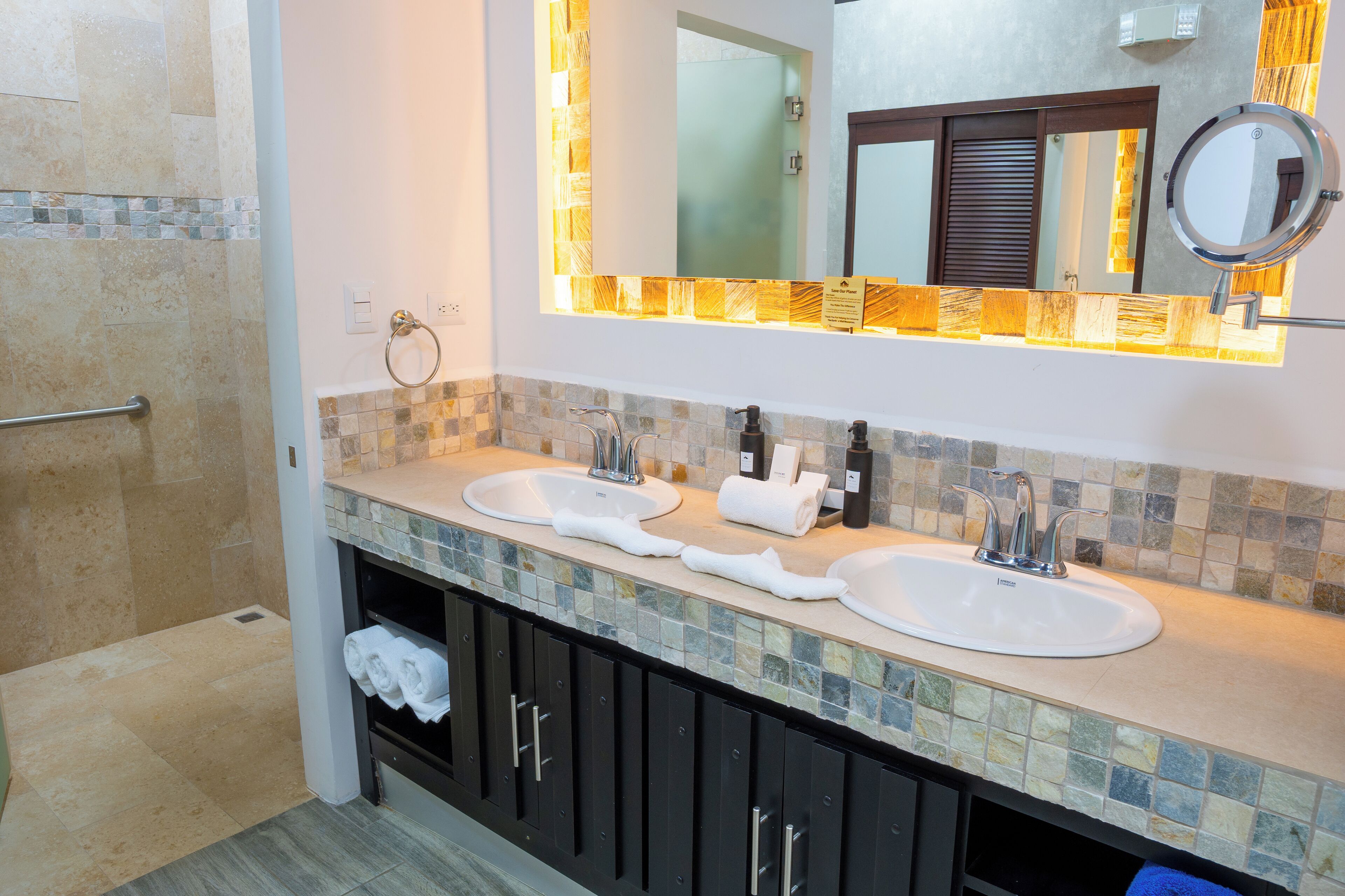 A bathroom with two sinks, a mirror, and a towel rack.