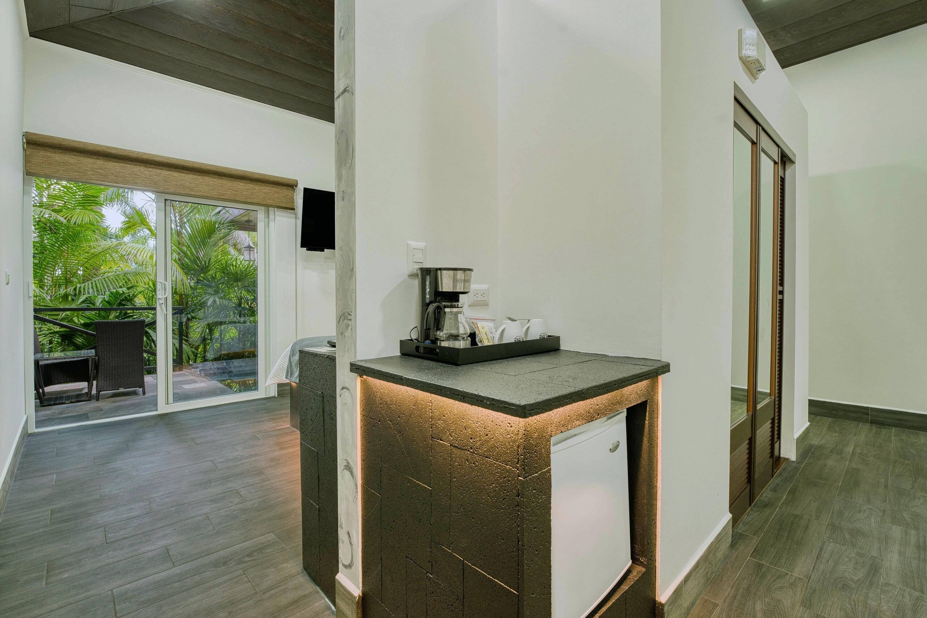 A modern kitchen with a built-in island, a coffee machine, and a view of a patio with outdoor furniture.