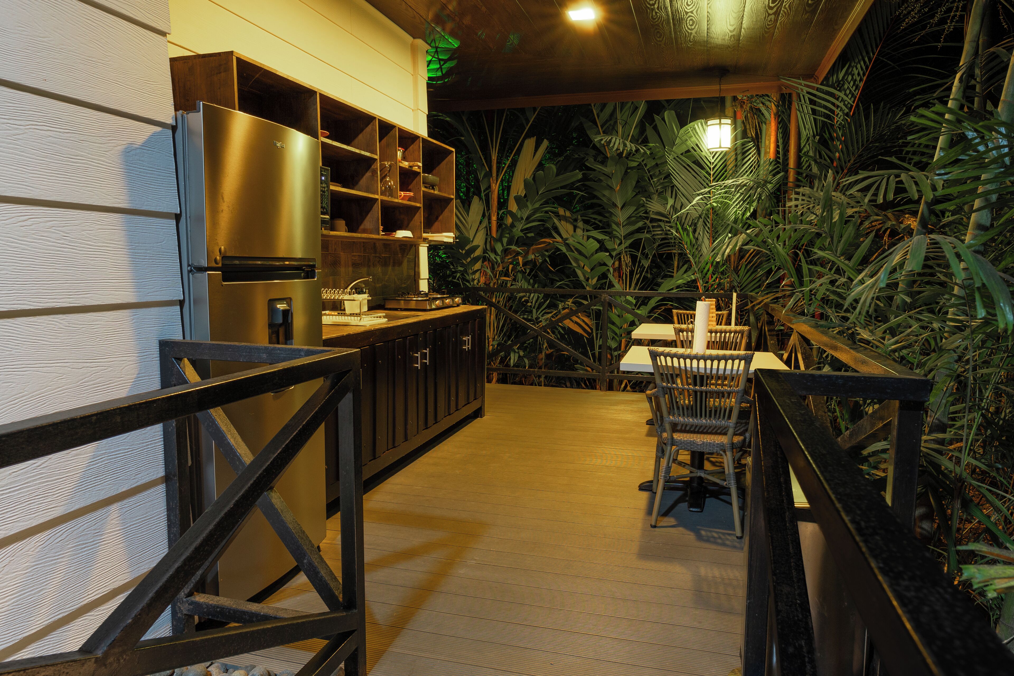 A kitchen with a stainless steel refrigerator, wooden cabinets, and a dining area with a table and chairs.