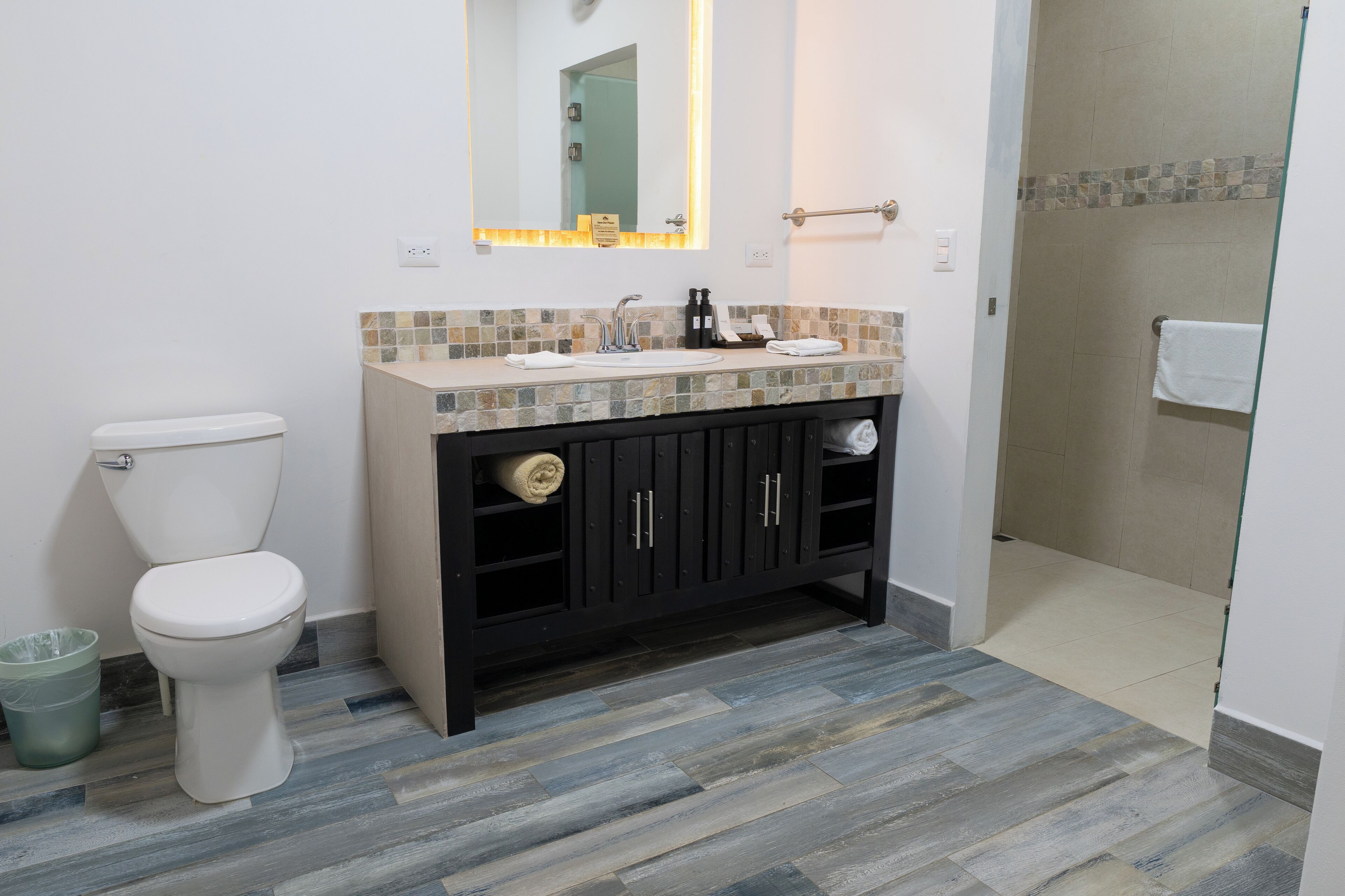 Un baño con inodoro, lavamanos y zona de ducha.