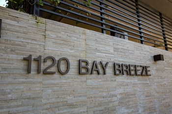 A Dolce & Gabbana store with mannequins displaying dresses, shelves with handbags, and a ceiling fan. at Bay Breeze Premium Apartments By Eskape Collection