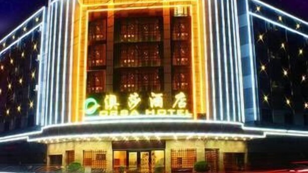 A hotel with a large, illuminated facade and a sign in a foreign language. - Orsa Hotel (Jiangmen)