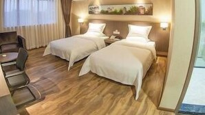 A hotel room with two beds, a desk, and a chair. - Orsa Hotel (Jiangmen)