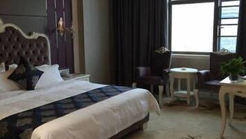 Une chambre d’hôtel avec un grand lit, une petite table, une chaise et une vue sur l’extérieur par une fenêtre.