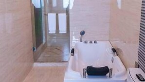 A modern bathroom with a bathtub, toilet, and glass shower enclosure. - Diyuan Boutique Garden Hotel (Shanghai)
