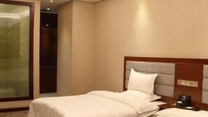 A hotel room with two beds, a wooden headboard, and a carpeted floor.