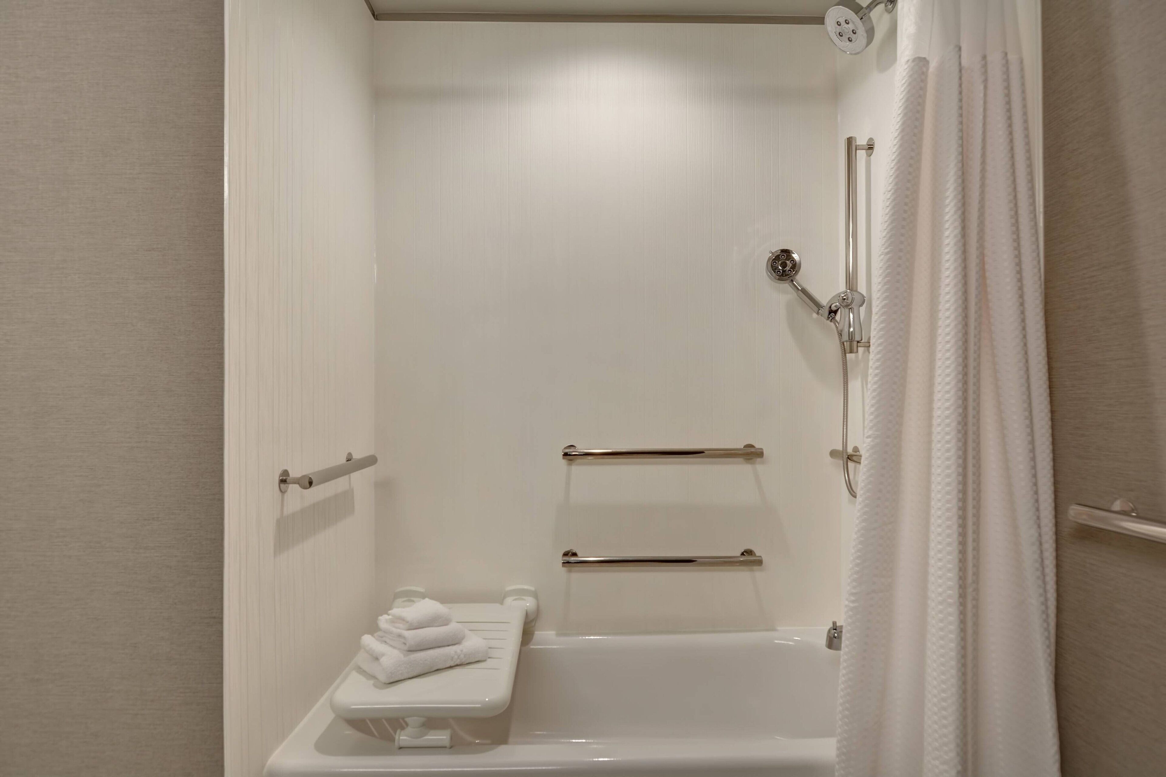 Un baño con una bañera blanca, un perchero y un calentador de toallas.