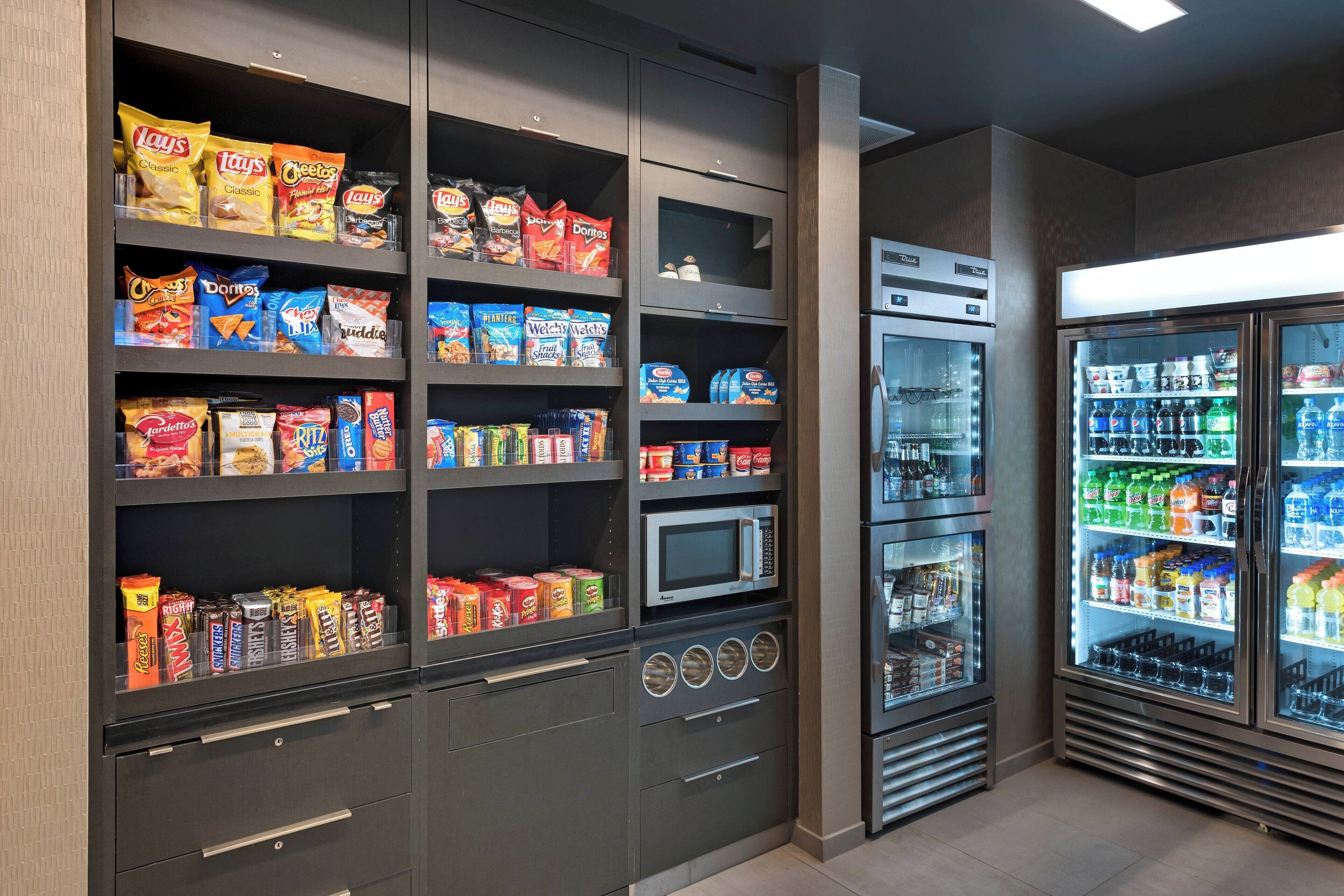 A snack and beverage section with various packaged snacks and a microwave.