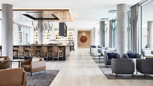 A modern hotel lobby with a central bar, seating areas, and large windows. - AC Hotel by Marriott Phoenix Biltmore (Phoenix)
