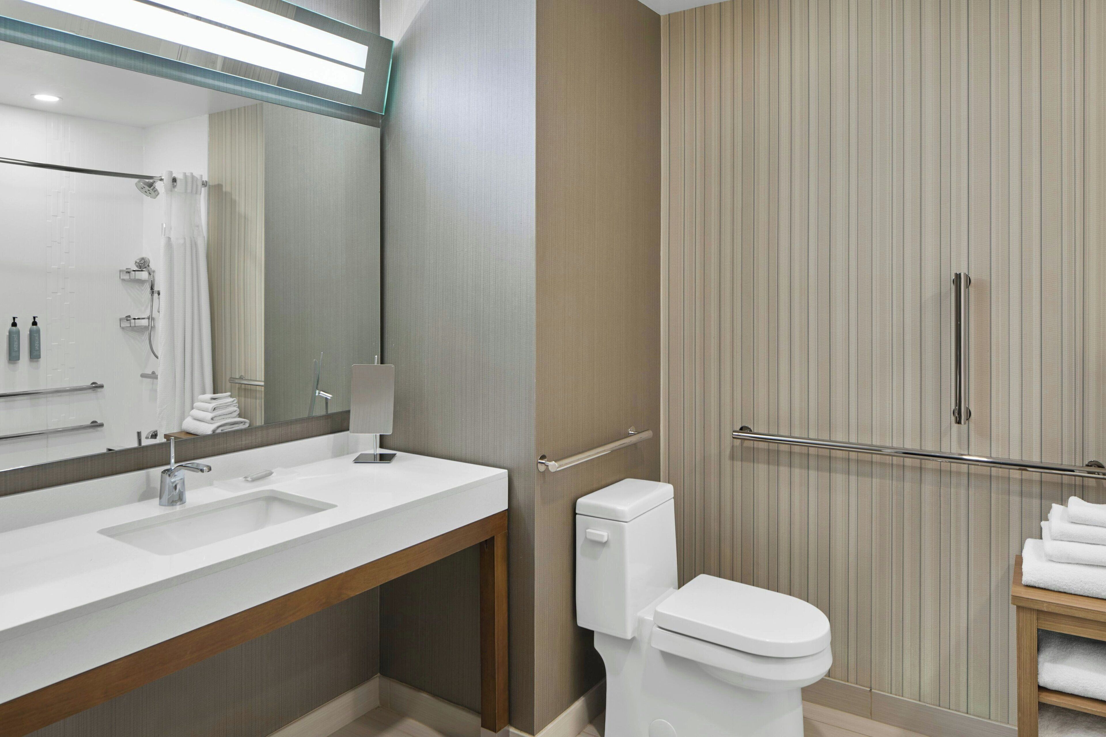 Une salle de bain moderne avec un double lavabo, des toilettes et un espace douche.