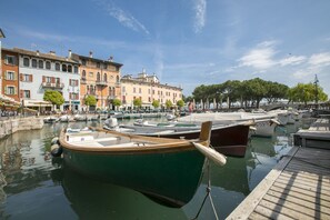 A marina with boats docked, a wooden dock, and historic buildings in the background. - Appartamento Vista Lago: Pool, Garage & Lake View, Desenzano Del Garda, Italy (Desenzano Del Garda)