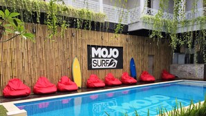 En swimmingpool med en trævæg og et skilt, der står "MOJO SURF".