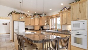 A spacious kitchen with a large island, wooden cabinets, and modern appliances. - Mountain Views w/ Hot Tub (Tabernash)