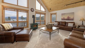 A spacious living room with large windows, a fireplace, and a cozy seating area. - Mountain Views w/ Hot Tub (Tabernash)