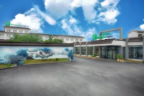Un hôtel Holiday Inn Express doté d’une architecture traditionnelle et orné d’une fresque représentant un paysage paisible.