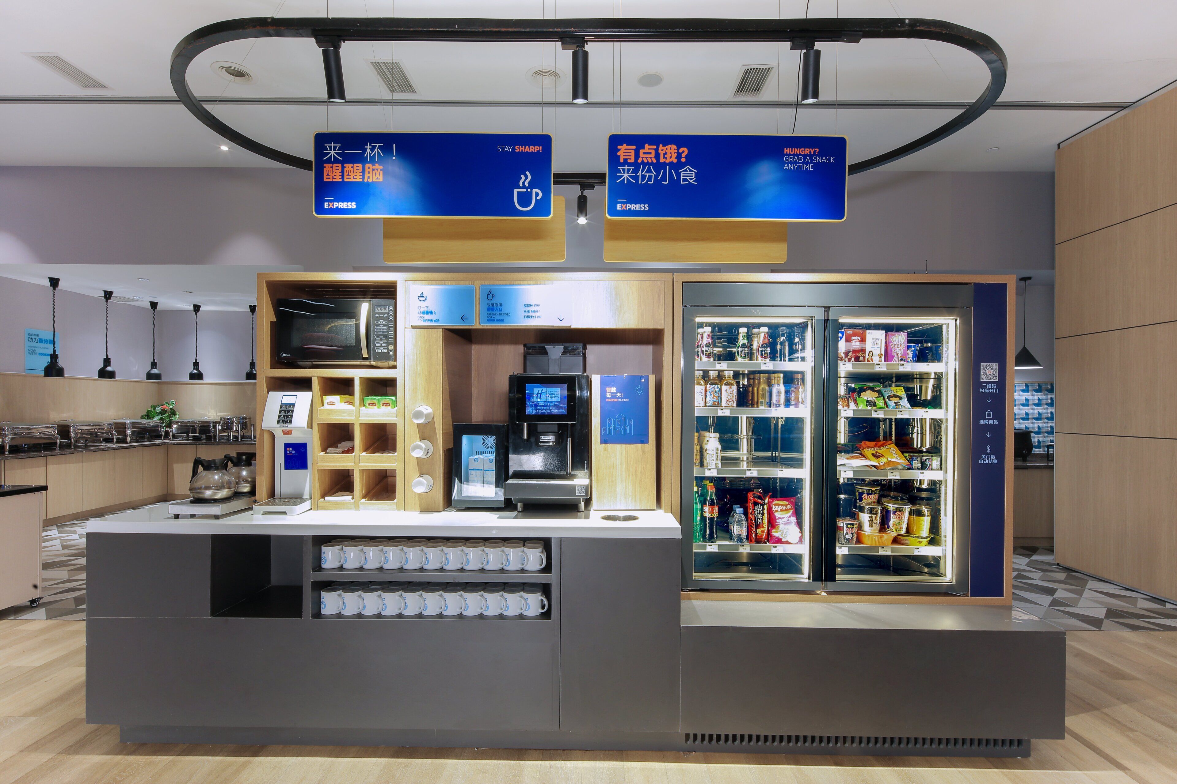 Una estación autoservicio de café con una máquina de café, espumador de leche y una variedad de bebidas.
