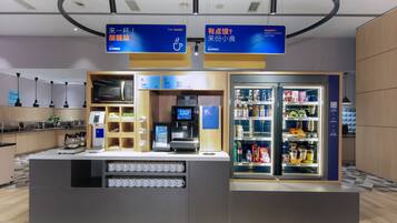 Una estación autoservicio de café con una máquina de café, espumador de leche y una variedad de bebidas.