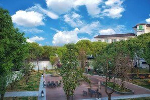 Une cour avec des sièges en plein air, entourée d’arbres et d’un bâtiment portant l’enseigne d’un hôtel Holiday Inn Express.
