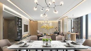 Een moderne eetruimte met een marmeren tafel, stijlvolle stoelen en een kroonluchter.