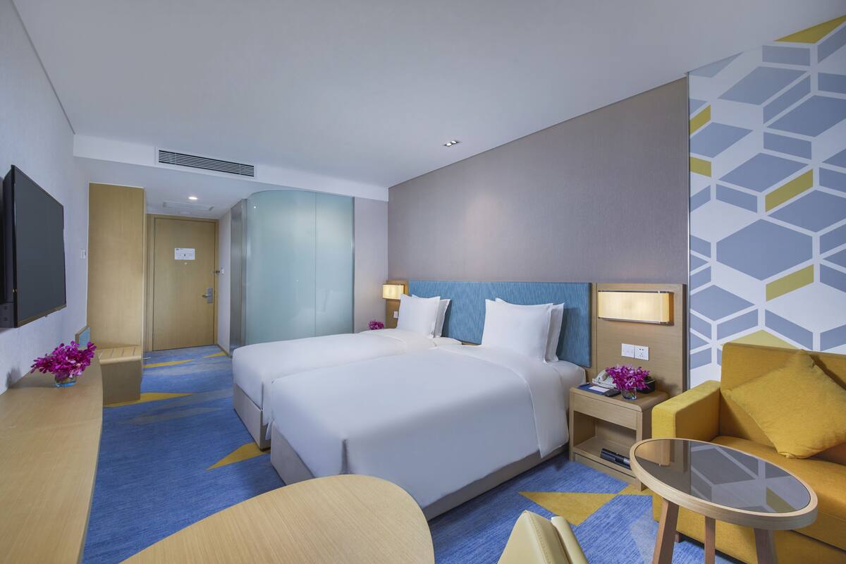 Une chambre d’hôtel avec un grand lit, un canapé, une petite table et un téléviseur.