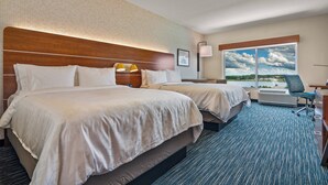 A hotel room with two beds, a desk, and a view of the outdoors. - Holiday Inn Express & Suites Orlando - Lake Buena Vista by IHG (Orlando)
