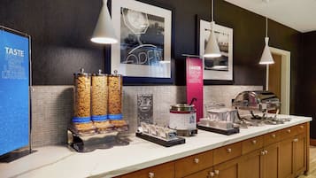 A buffet area with various food items, a coffee machine, and a sign promoting a 'Rock & Roll Casserole'.