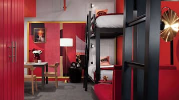 Een hotelkamer met een stapelbed, een bureau met stoel, een lamp en een schilderij aan de muur.