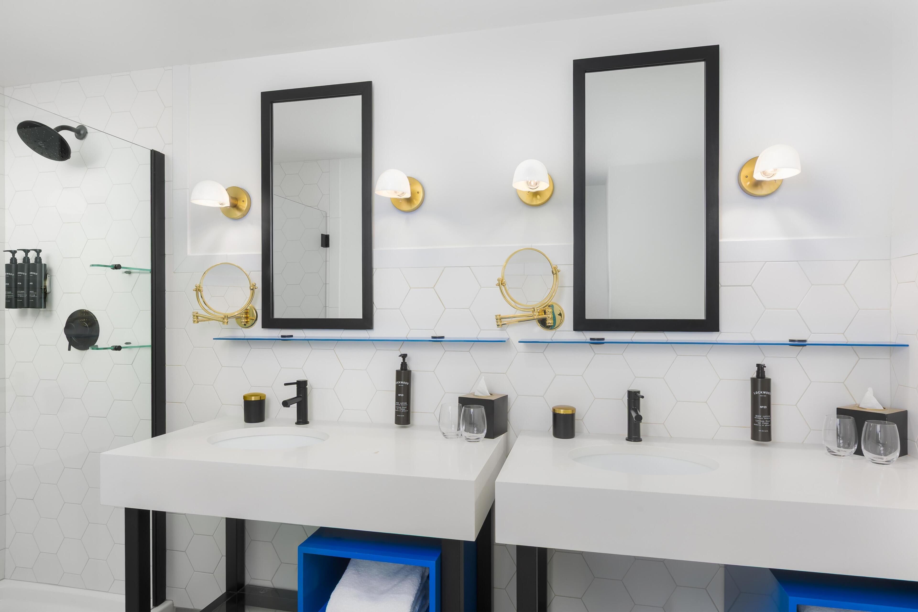 A modern bathroom with two sinks, mirrors, and toiletries.
