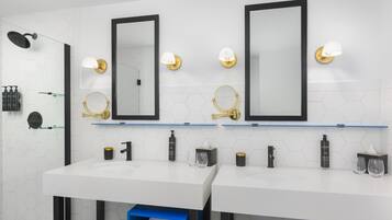 A modern bathroom with two sinks, mirrors, and toiletries.