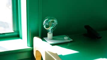 A room with a window, a desk, and a lamp.