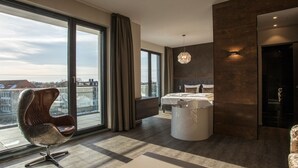 A modern bedroom with a large window, a bed, a chair, and a unique light fixture. - Deck 8 Designhotel.Soest (Soest)