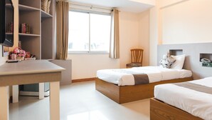 A modern hotel room with a large window, a desk with a chair, a bookshelf, and two beds. - K.S. Pavilion Hotel (Nakhon Ratchasima)