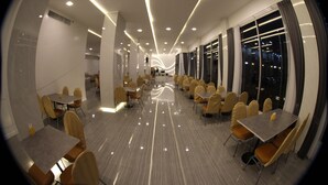 A modern hotel lobby with a long corridor, multiple dining areas, and large windows. - K.S. Pavilion Hotel (Nakhon Ratchasima)
