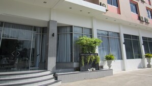 A modern building with large windows, a flat roof, and a staircase leading to the entrance. - K.S. Pavilion Hotel (Nakhon Ratchasima)