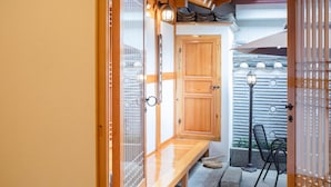 Una habitació tradicional japonesa amb tatamis, una porta de fusta i una porta corredissa de vidre que dona a un balcó.