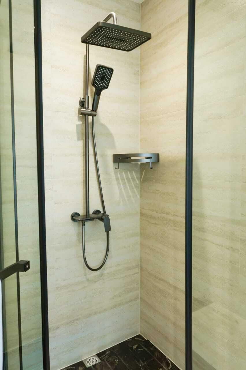 A shower with a handheld showerhead and a wall-mounted rain showerhead.
