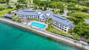A resort with a pool, multiple buildings, and a waterfront view.