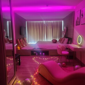 A modern bedroom with a bed, bedside tables, a desk, and a chair. - The MCR Luxury Nha Trang Hotel (Nha Trang)