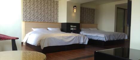 A hotel room with two beds, a desk, and a chair.